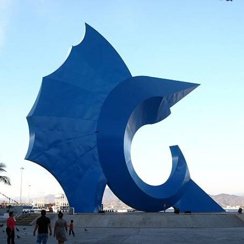 Manzanillo, Mexico - March 21, 2013: People stop to view the Blue Fish sculpture, Pez espada, in the plaza and gardens of downtown Manzanillo, Mexico